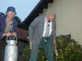 Bauer Eugen und sein Knecht schauen in den Hof zu den Gästen